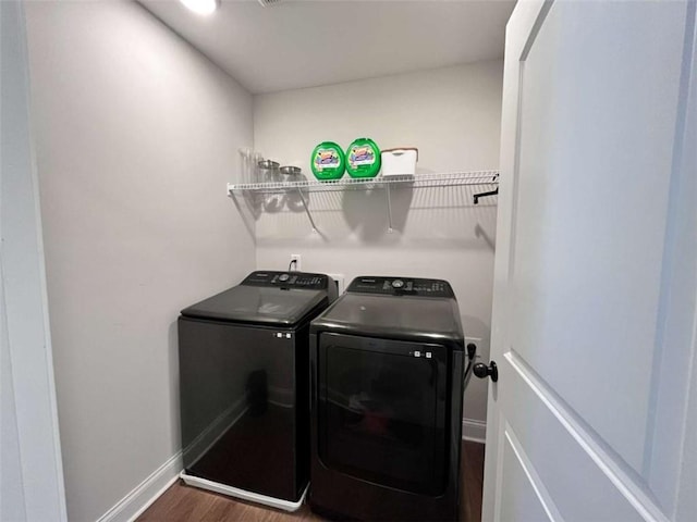 washroom featuring washing machine and dryer and dark hardwood / wood-style floors