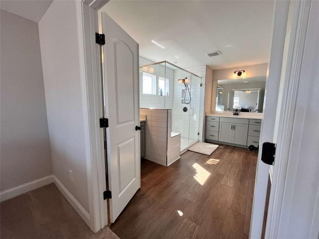 bathroom featuring vanity, hardwood / wood-style floors, and a shower with shower door