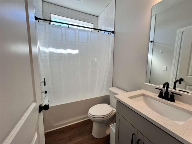 full bathroom featuring hardwood / wood-style flooring, shower / tub combo with curtain, vanity, and toilet