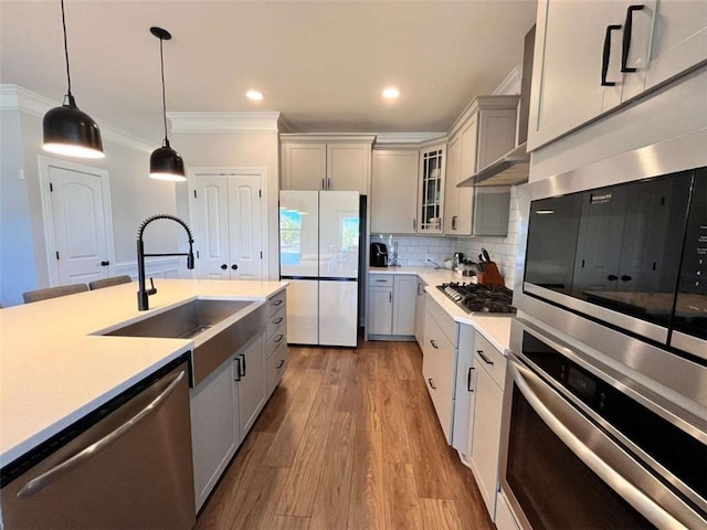 kitchen with appliances with stainless steel finishes, tasteful backsplash, sink, gray cabinetry, and hanging light fixtures