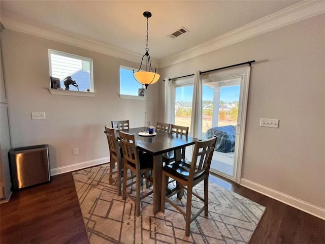 dining area featuring crown molding, a healthy amount of sunlight, and dark hardwood / wood-style flooring