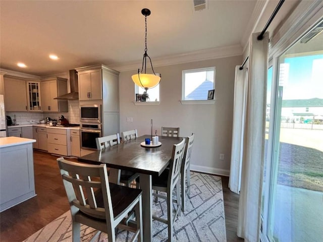 dining space featuring crown molding and dark wood-type flooring