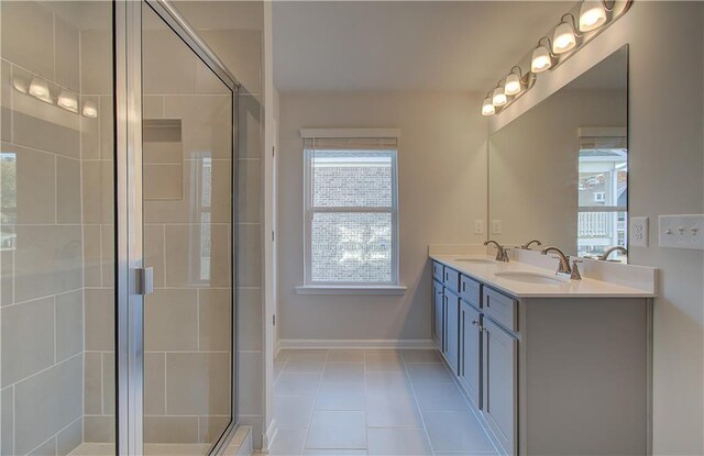 bathroom featuring a shower with door, vanity, and tile patterned floors