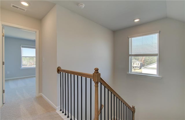 hall featuring light carpet and vaulted ceiling