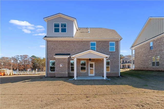 back of property with a lawn and a patio area