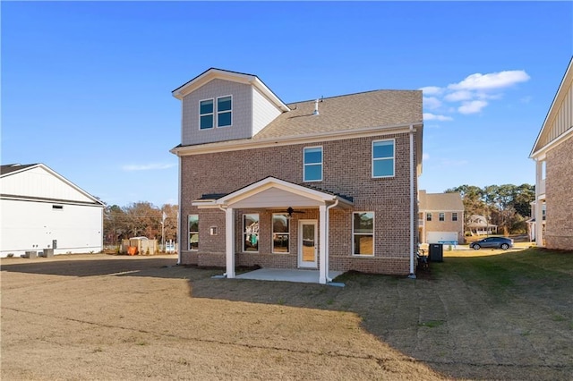 rear view of property featuring a yard and a patio area