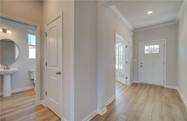 foyer featuring crown molding and light hardwood / wood-style flooring