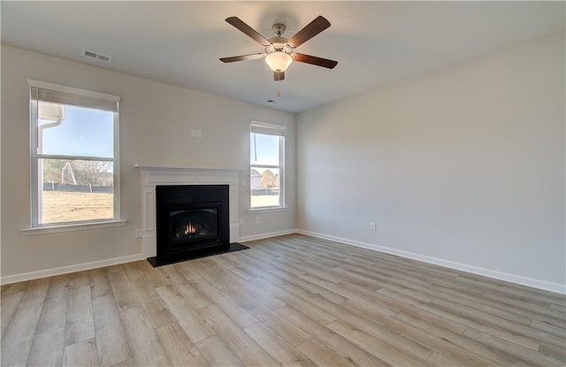 unfurnished living room with ceiling fan, light hardwood / wood-style floors, and a healthy amount of sunlight