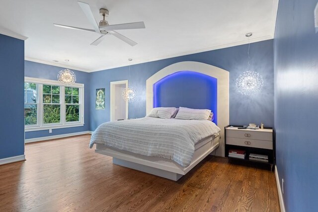 bedroom with ceiling fan, dark hardwood / wood-style floors, and ornamental molding