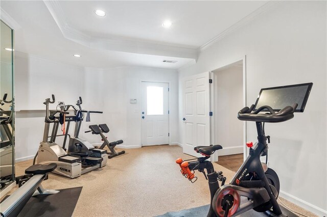 exercise area featuring a tray ceiling and crown molding