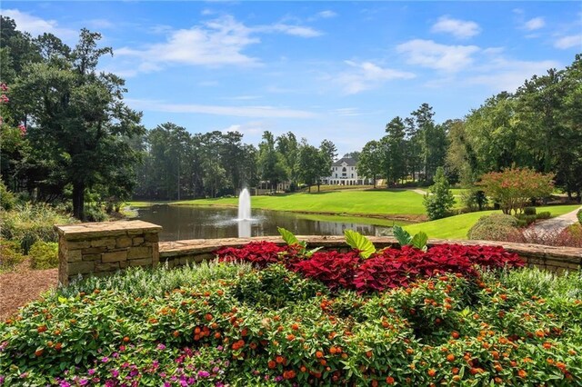 view of community featuring a lawn and a water view