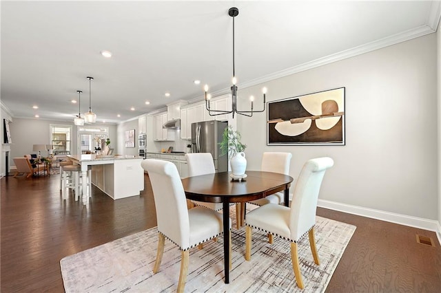 dining space featuring dark wood-style flooring, crown molding, recessed lighting, visible vents, and baseboards