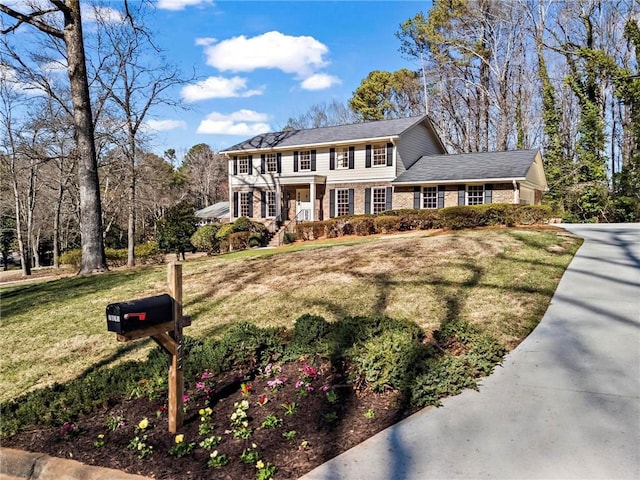 view of front of property featuring brick siding and a front yard