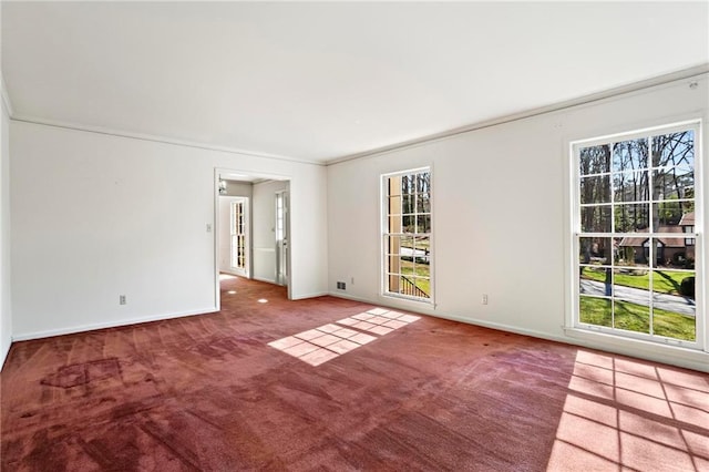 carpeted empty room featuring baseboards and crown molding