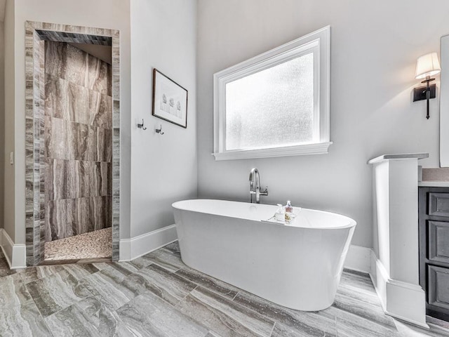 5039 Towne Lake Hls N, Woodstock, GA 30189 - bathroom featuring a walk in shower, a freestanding bath, and baseboards