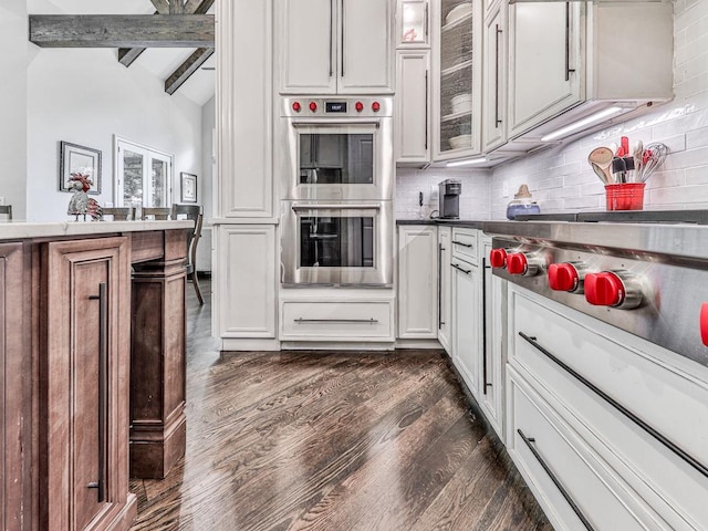 5039 Towne Lake Hls N, Woodstock, GA 30189 - kitchen with stainless steel double oven, dark wood-style floors, tasteful backsplash, glass insert cabinets, and white cabinets