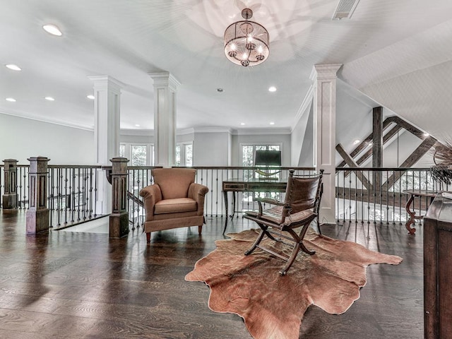 5039 Towne Lake Hls N, Woodstock, GA 30189 - sitting room featuring crown molding, an upstairs landing, decorative columns, a chandelier, and wood finished floors