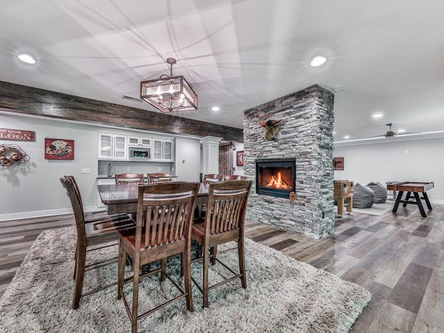 5039 Towne Lake Hls N, Woodstock, GA 30189 - dining space featuring wood finished floors, decorative columns, baseboards, a fireplace, and recessed lighting