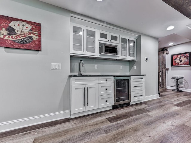5039 Towne Lake Hls N, Woodstock, GA 30189 - indoor wet bar with beverage cooler, wood finished floors, baseboards, and recessed lighting