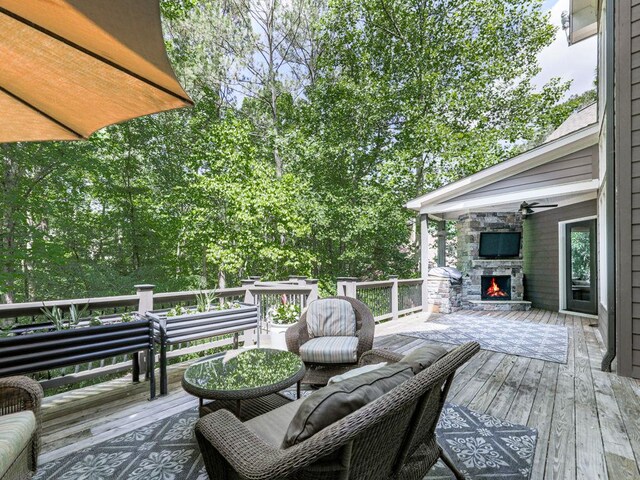 5039 Towne Lake Hls N, Woodstock, GA 30189 - wooden deck featuring an outdoor stone fireplace and ceiling fan