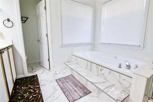 full bathroom featuring vanity, baseboards, toilet, a bath, and marble finish floor