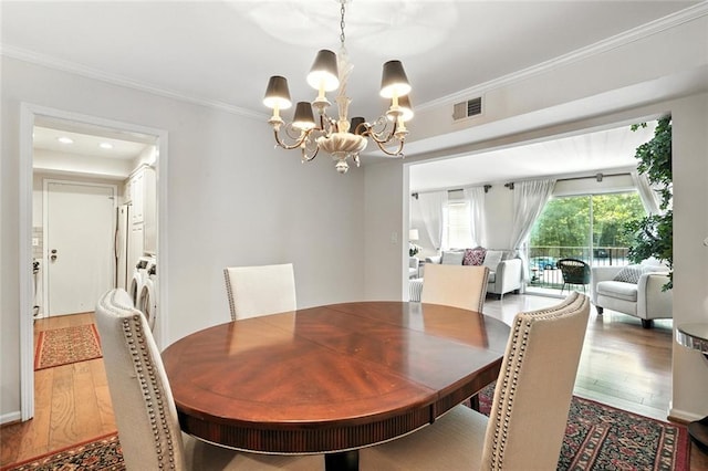 6851 Roswell Rd Unit F5, Sandy Springs, GA 30328 - dining room with wood finished floors, a chandelier, crown molding, and washer / clothes dryer