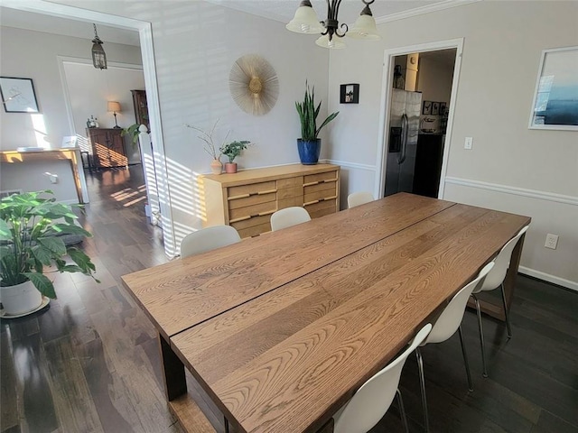 dining space with dark hardwood / wood-style flooring, crown molding, and an inviting chandelier