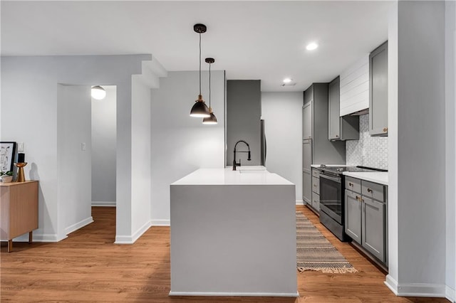 kitchen featuring sink, tasteful backsplash, gray cabinets, pendant lighting, and appliances with stainless steel finishes