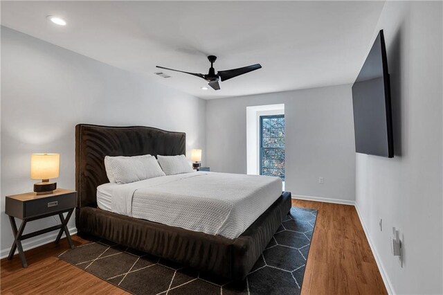 bedroom with ceiling fan and dark wood-type flooring