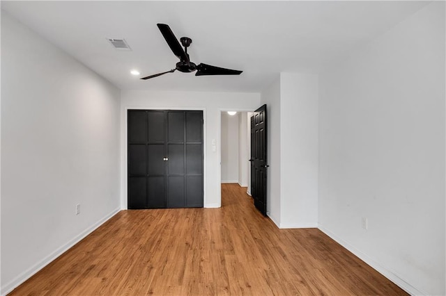 unfurnished bedroom featuring ceiling fan, light hardwood / wood-style floors, and a closet