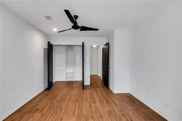 unfurnished bedroom featuring light hardwood / wood-style floors, ceiling fan, and a closet