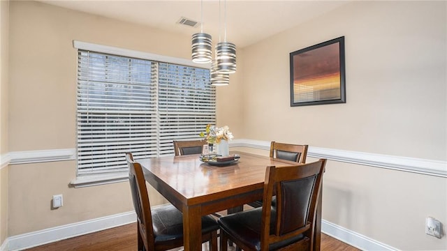 dining area featuring visible vents, baseboards, and wood finished floors