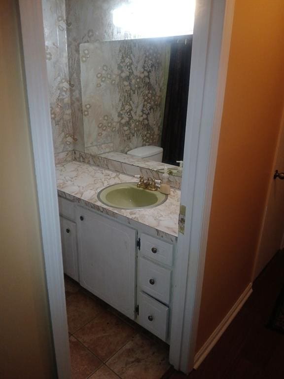 bathroom with tile patterned flooring, vanity, and toilet