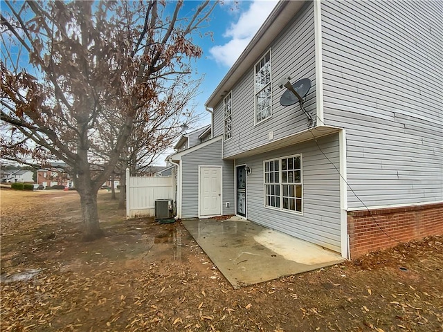 rear view of property with fence, central AC, and a patio