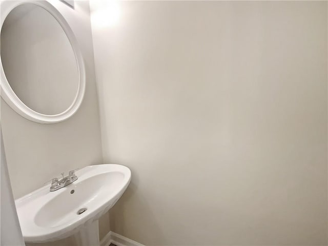 bathroom featuring baseboards and a sink