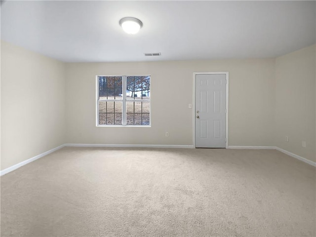 spare room featuring baseboards, visible vents, and carpet flooring