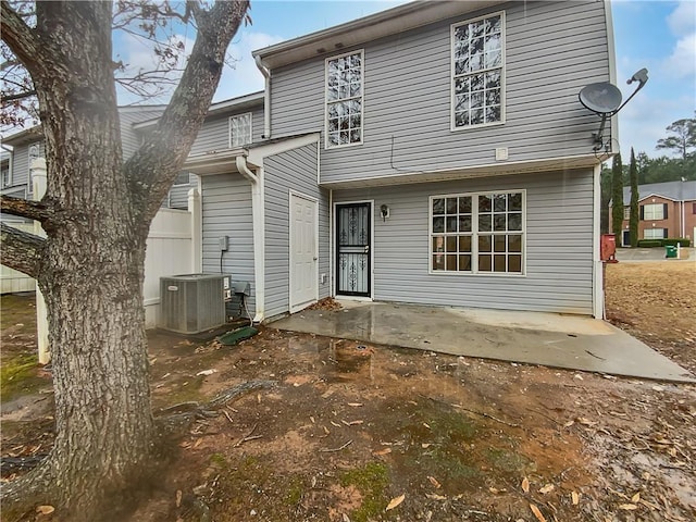 back of property with central AC unit and a patio area