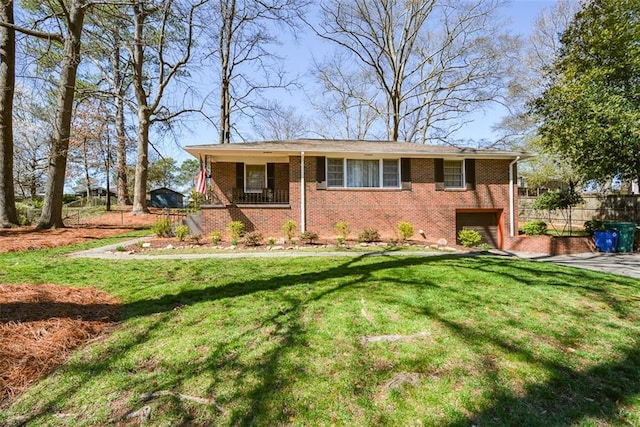 view of front of home with driveway, brick siding, and a front yard