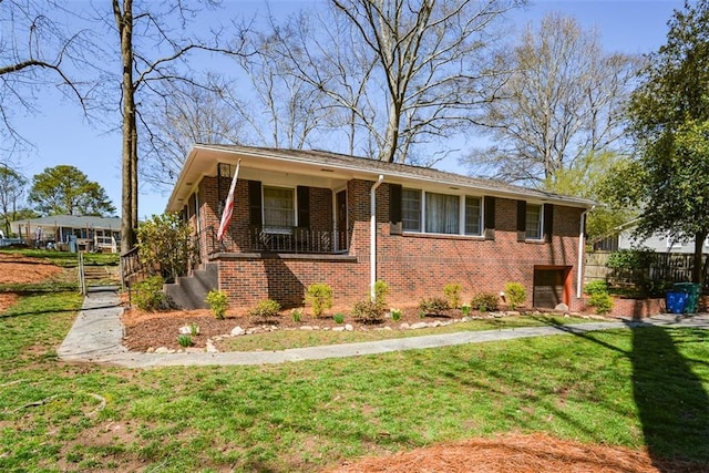 view of front of house with brick siding, a front lawn, and fence