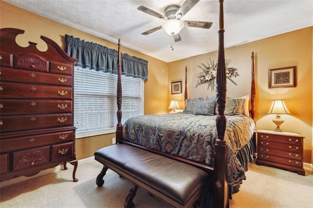 bedroom featuring baseboards, ceiling fan, a textured ceiling, and light colored carpet