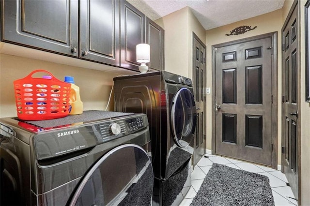 washroom with light tile patterned floors, a textured ceiling, cabinet space, and washer and dryer