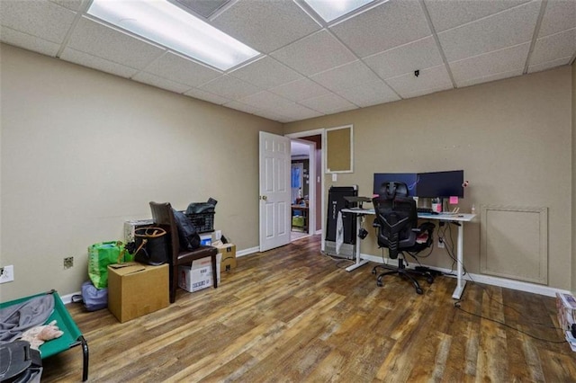 home office with a drop ceiling, baseboards, and wood finished floors