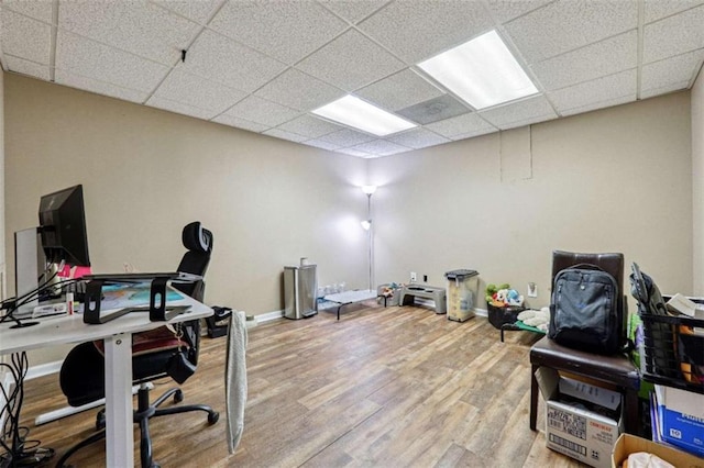 home office with a paneled ceiling, baseboards, and wood finished floors