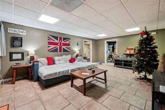 bedroom with a paneled ceiling and baseboards