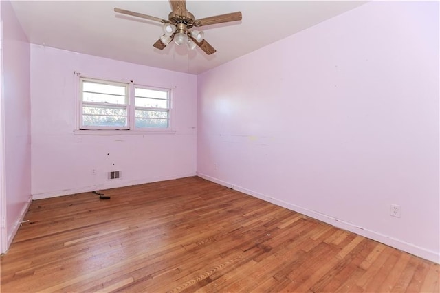 spare room featuring baseboards, light wood-style flooring, visible vents, and a ceiling fan