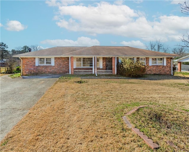 ranch-style house featuring aphalt driveway, a front yard, and brick siding