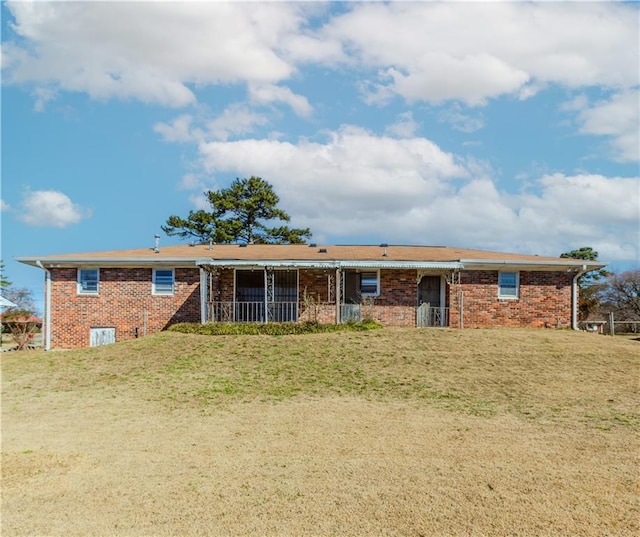 rear view of property with a yard and brick siding