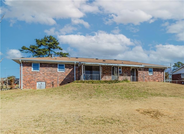 rear view of property featuring brick siding and a yard