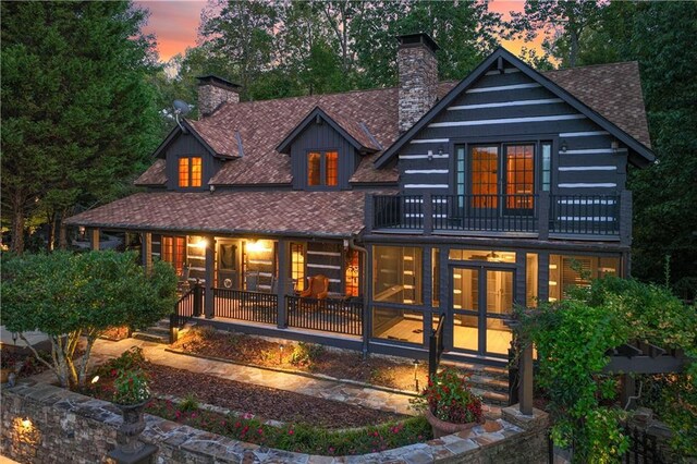 3464 Carolyn St, Gainesville, GA 30504 - back of house at dusk featuring a balcony, a chimney, and roof with shingles