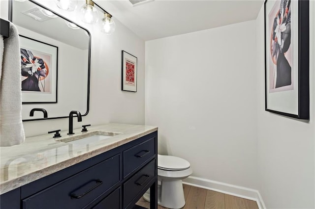 bathroom with vanity, hardwood / wood-style floors, and toilet